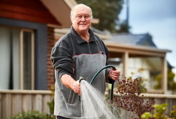 Man watering garden by - Craig Moodie