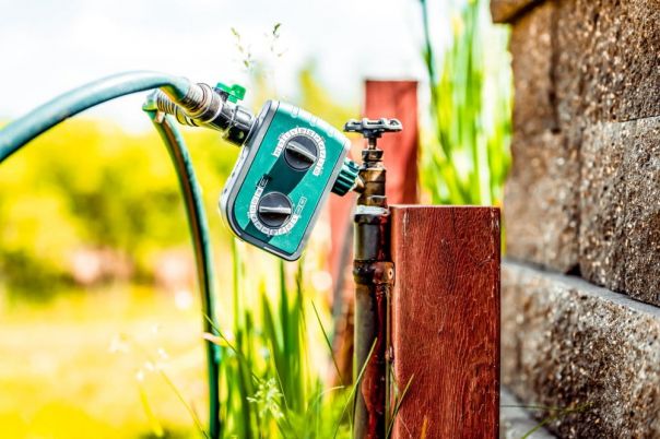 Garden water timer on a spigot with a splitter and hoses.