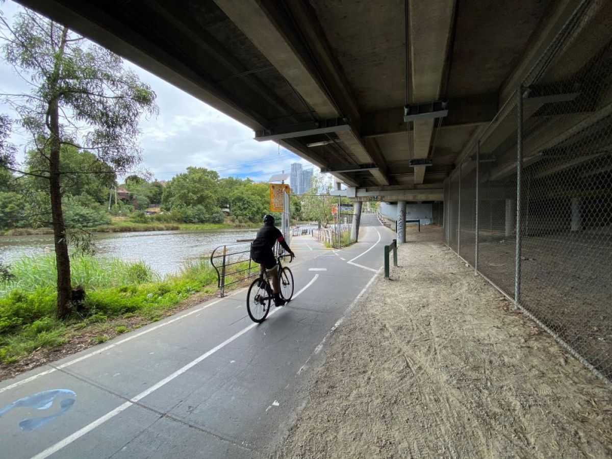 Cycling under bridge next to Yarra River