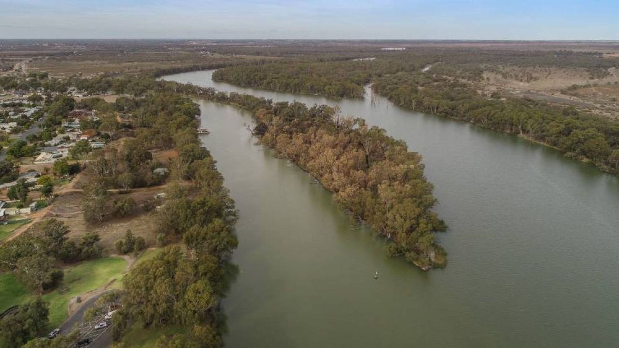 Two rivers converge with greenery and townships alongside it.